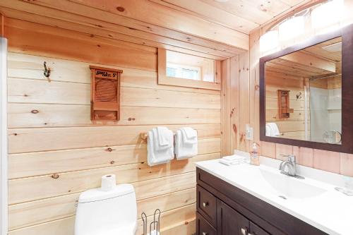 ein Holzbadezimmer mit einem Waschbecken und einem Spiegel in der Unterkunft Easton Escape a notch above in Sugar Hill