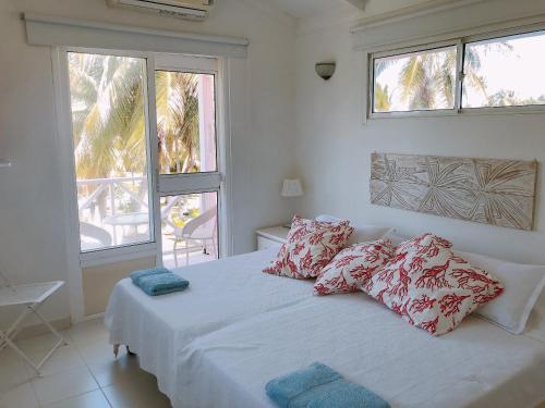 uma cama branca com almofadas num quarto em Sitio exclusivo y tranquilo em San Andrés