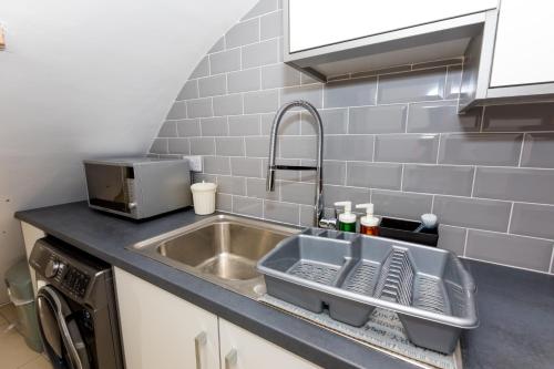 um lavatório de cozinha com um suporte para secar pratos ao lado em Comfortable stay in Shirley, Solihull - Room-2 em Solihull