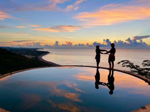 two people are standing on the edge of a body of water at Color Rainbow Home in Taimali