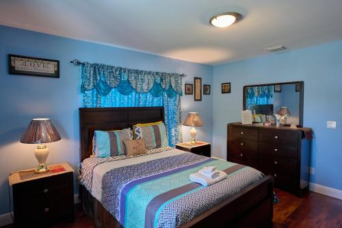una camera da letto con pareti blu e un letto con due lampade di Fabulous Hollywood Living Space a Hollywood