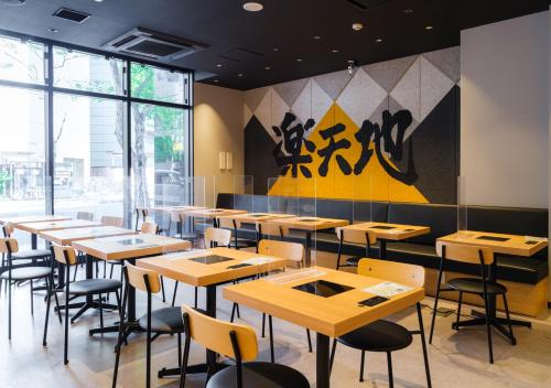 ein Restaurant mit Holztischen und -stühlen und einem Wandbild in der Unterkunft APA Hotel & Resort Hakata Ekihigashi in Fukuoka