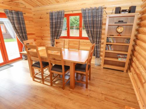 a dining room with a wooden table and chairs at Maple Lodge in Oakham