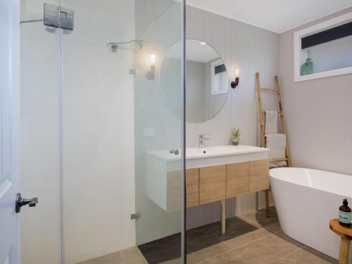 a bathroom with a tub and a sink and a shower at Ocean Willow Gerringong in Gerringong
