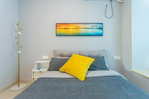 a bedroom with a bed with a yellow pillow on it at Sanya Sun Seaview Apartment in Sanya