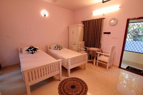 a living room with two beds and a table at Nirrvaan homestay in Varkala