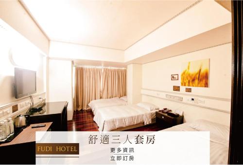 a hotel room with two beds and a television at Fudi Hotel in Taichung