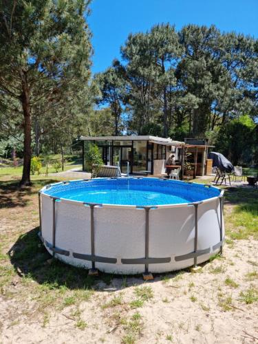 a large circular pool in a yard with a house at Ohana Punta Ballena cero nueve siete tres uno ocho ocho nueve cinco in Punta del Este