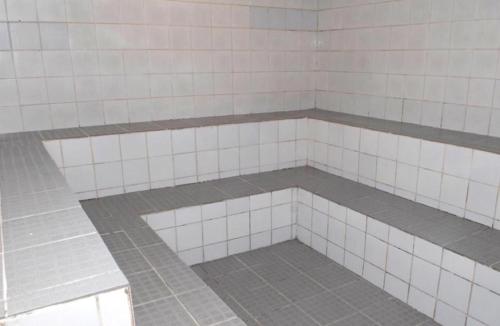a white tiled shower in a bathroom at Porto Real Suítes Mangaratiba in Mangaratiba
