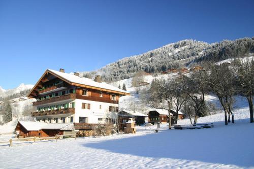 un grand bâtiment dans la neige devant une montagne dans l'établissement Esprit Montagne, à La Chapelle-dʼAbondance