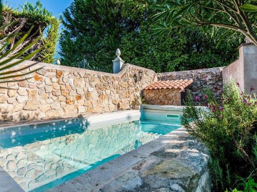 a swimming pool next to a stone wall at Charming holiday home in Lorgues with pool in Lorgues