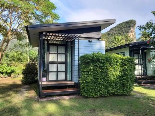 a small blue tiny house with a porch at Baan Rim Nam Resort in Phangnga