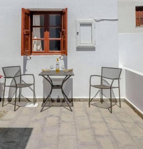 a table and chairs in a room with a window at Barvas studios Lindos in Lindos