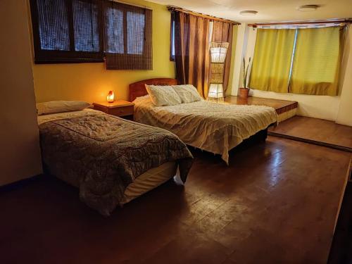 1 dormitorio con 2 camas y ventana en apartamento gamboni, en Iquique