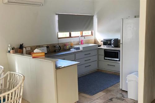 a kitchen with white cabinets and a stove top oven at Beachside 5 with Ocean glimpses in Port Douglas