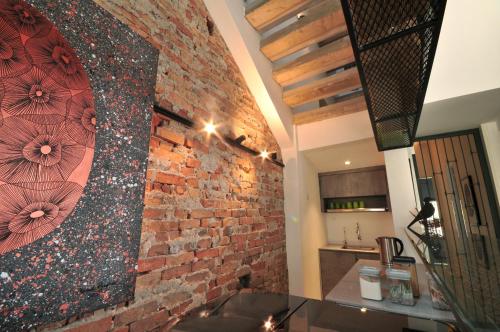 een bakstenen muur met een grote spiegel erop bij The Nest House in Melaka