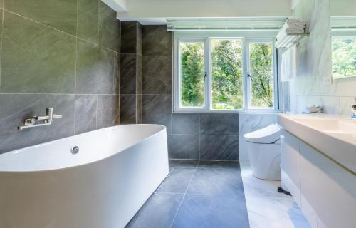 a white bath tub in a bathroom with a window at Revel Villa in Puli