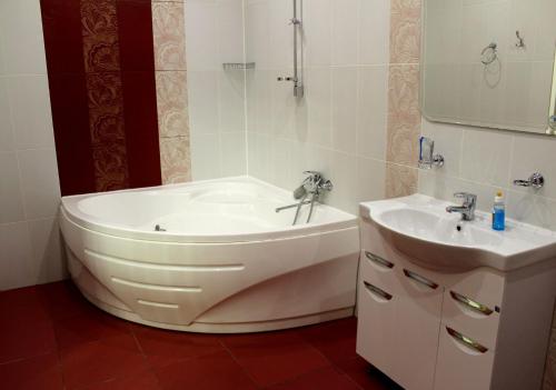 y baño con bañera y lavamanos. en Cruise Hotel, en Perm