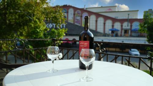 uma garrafa de vinho sentada numa mesa com dois copos em ALINA'S ROOM em Kutaisi