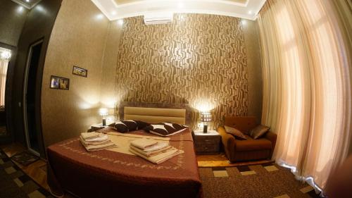a bedroom with a bed and a chair in a room at ALINA'S ROOM in Kutaisi