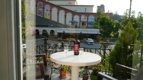 a white table with two glasses of wine on a balcony at ALINA'S ROOM in Kutaisi