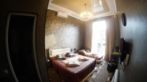 a bedroom with a bed and a couch and a window at ALINA'S ROOM in Kutaisi