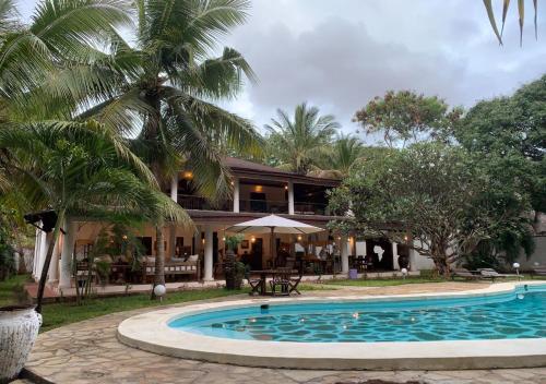 a house with a swimming pool in front of a house at Kenyan House Malindi in Malindi