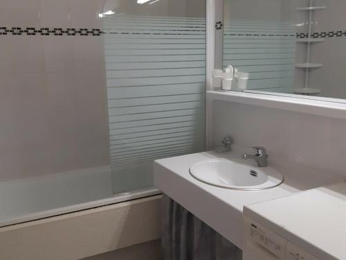 y baño blanco con lavabo y ducha. en Studio Les Deux Alpes, 1 pièce, 4 personnes - FR-1-516-82, en Les Deux Alpes