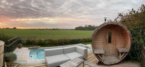 d'un petit bain à remous avec un canapé à côté d'une terrasse. dans l'établissement Gîte de l'Étang, à Frasnes-lez-Anvaing