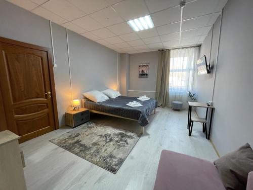 - une chambre avec un lit, une table et une porte dans l'établissement Подворье, à Moscou