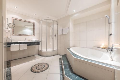 a bathroom with a tub and a shower and a sink at Alpenschlössl Boutique Appartements & Rooms in Neustift im Stubaital