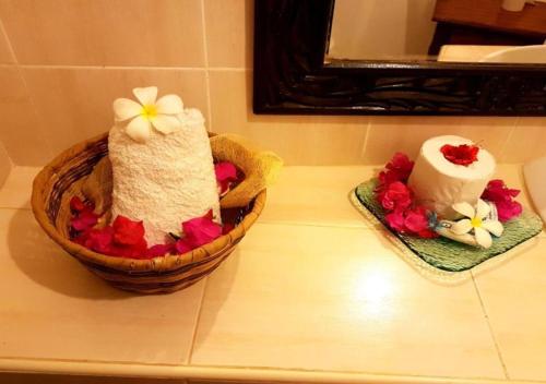 two towels in a basket on a counter with flowers at Kenyan House Malindi in Malindi