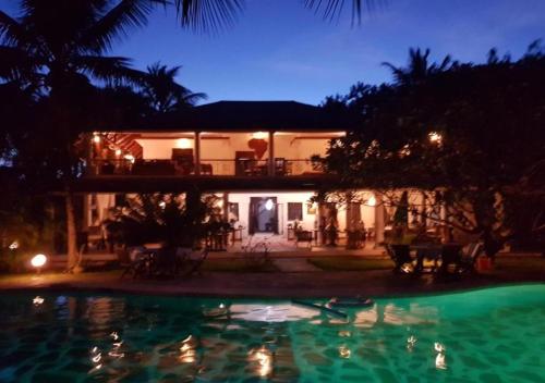 a house with a swimming pool at night at Kenyan House Malindi in Malindi