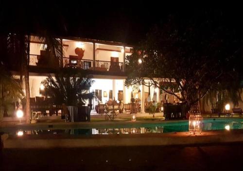 a building with a swimming pool at night at Kenyan House Malindi in Malindi