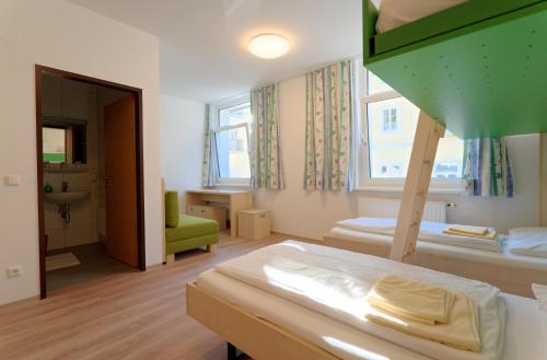 a bedroom with two bunk beds and a bathroom at Jugendg&auml;stehaus Bad Ischl in Bad Ischl