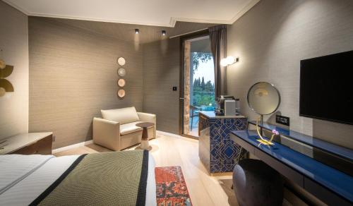 a hotel room with a bed and a chair and a television at The Inbal Jerusalem in Jerusalem