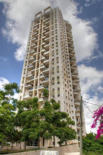 a tall white building with trees in front of it at Beautiful Penthouse w/amazing View, Prime location in Ramat Gan