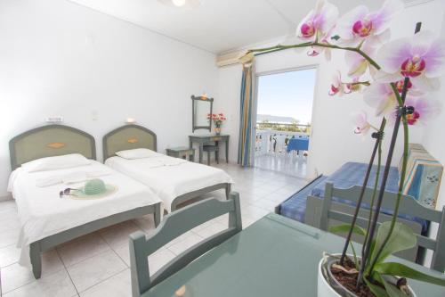 a hospital room with two beds and flowers in it at Papidakis Studios in Agia Marina Nea Kydonias