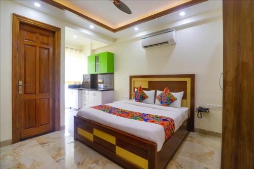 a bedroom with a large bed and a kitchen at FabHotel Star Corporate Suite in Gurgaon