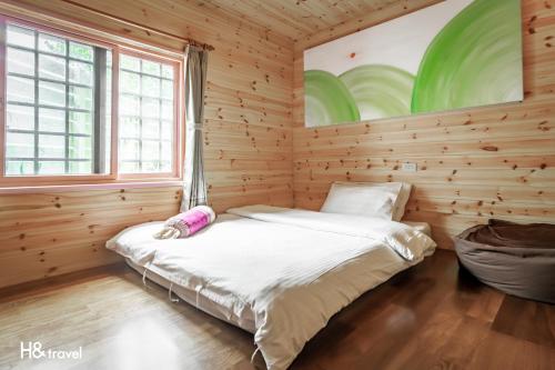 a bedroom with a bed in a wooden room at Alishan Sunrise B&B in Fanlu