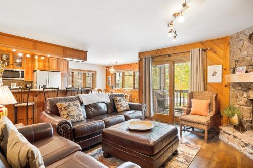 a living room with leather furniture and a stone fireplace at Phoenix 229 in Steamboat Springs
