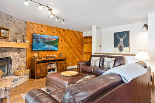 a living room with a leather couch and a fireplace at Phoenix 229 in Steamboat Springs