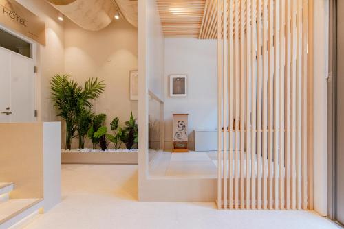 un vestíbulo con paredes blancas, suelos blancos y una escalera en 石畳ホテル, en Tokio
