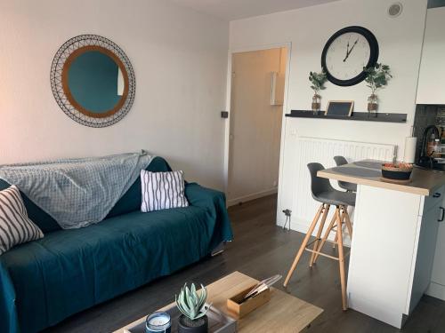 un salon avec un canapé vert et une table dans l'établissement Chaleureux appartement face au Port Sta Lucia, tout à pieds, wifi, à Saint-Raphaël