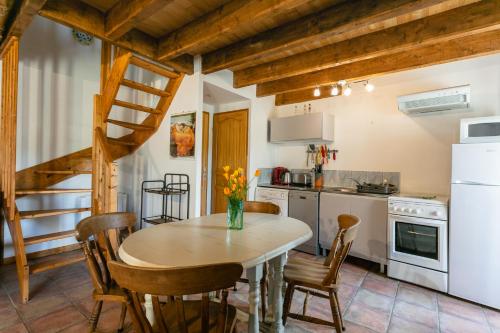 a kitchen with a table and chairs and a staircase at Gîtes Oasis du Lot in Payrac