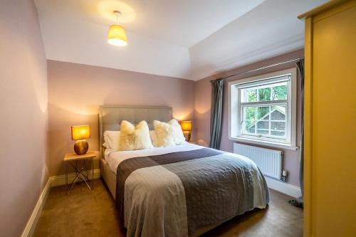 a bedroom with a bed with pillows and a window at Middlethorpe Manor - No 6 Tranquility & Ease in York