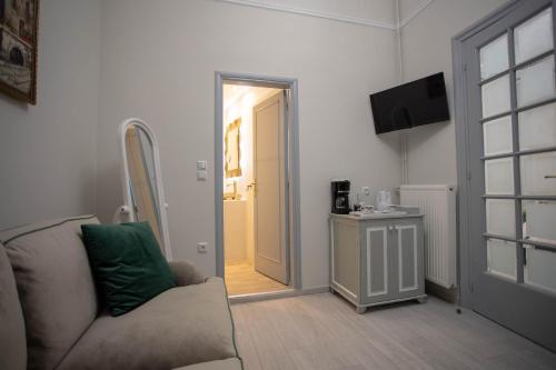 a living room with a couch and an open door at Pandrosos Divine Suites in Athens