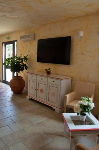 a living room with a flat screen tv on a wall at Hotel Trinità dei Corsari in Torre Dei Corsari