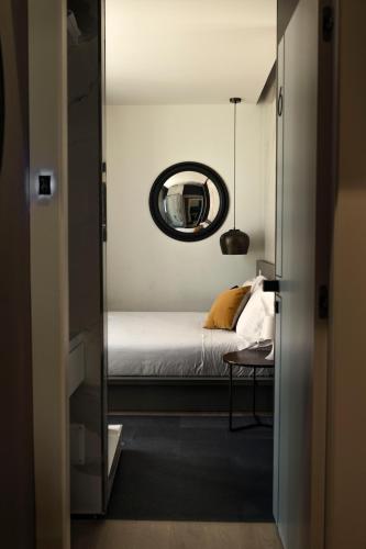 a bedroom with a bed and a mirror at Le Palmette Suites in Cagliari