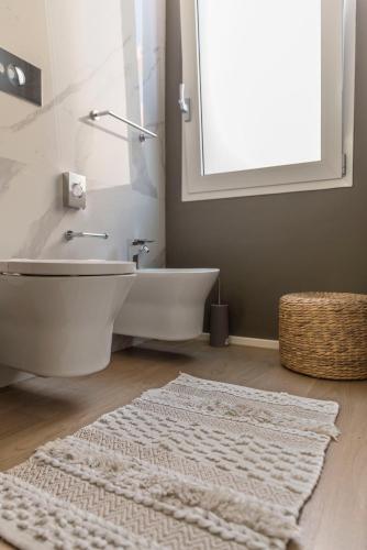 a bathroom with a white bath tub and a rug at Le Palmette Suites in Cagliari